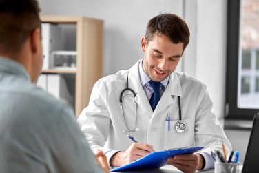 doctor with clipboard talking to patient.