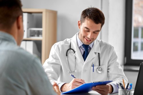 doctor with clipboard talking to patient.