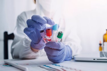 gloved technician holding sample tubes.