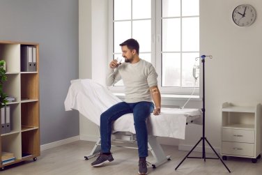 provider helping man receiving IV drip.