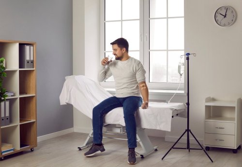 provider helping man receiving IV drip.