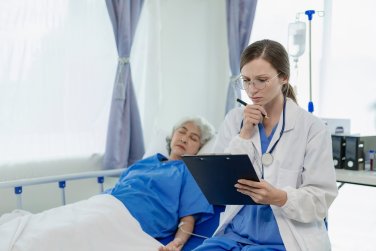 nhân viên xem clipboard khi bệnh nhân nhận truyền dịch.