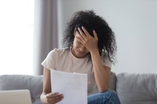 upset woman reading a sheet of paper.