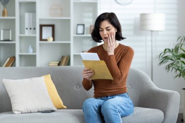 woman reads a sheet of paper and becomes upset.