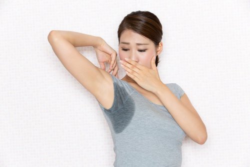 phụ nữ lộ nách ướt và che miệng.