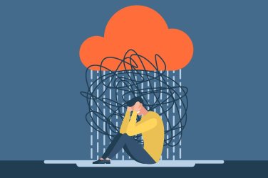 person sitting with head in hands, rain and clouds, showing distress.