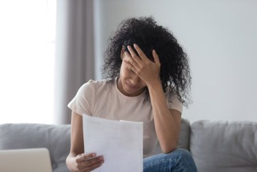 upset woman reading a sheet of paper.