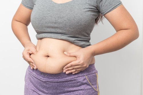 mujer pellizca grasa abdominal excesiva.