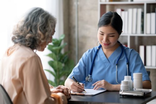 médico con clipboard habla con paciente.