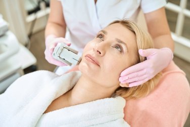 woman receiving facial laser treatment.